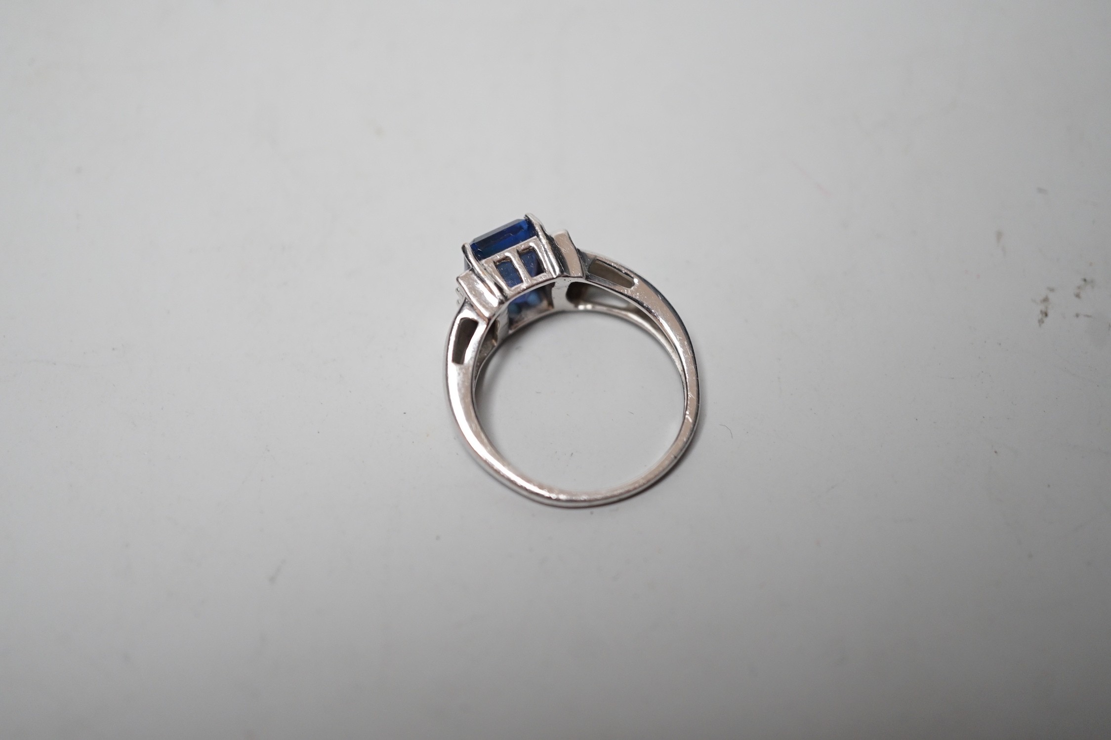 A modern 18k, single stone emerald cut tanzanite and six stone diamond cluster set ring, size O, gross weight 5 grams, with accompanying IGI report dated 6/9/2006.